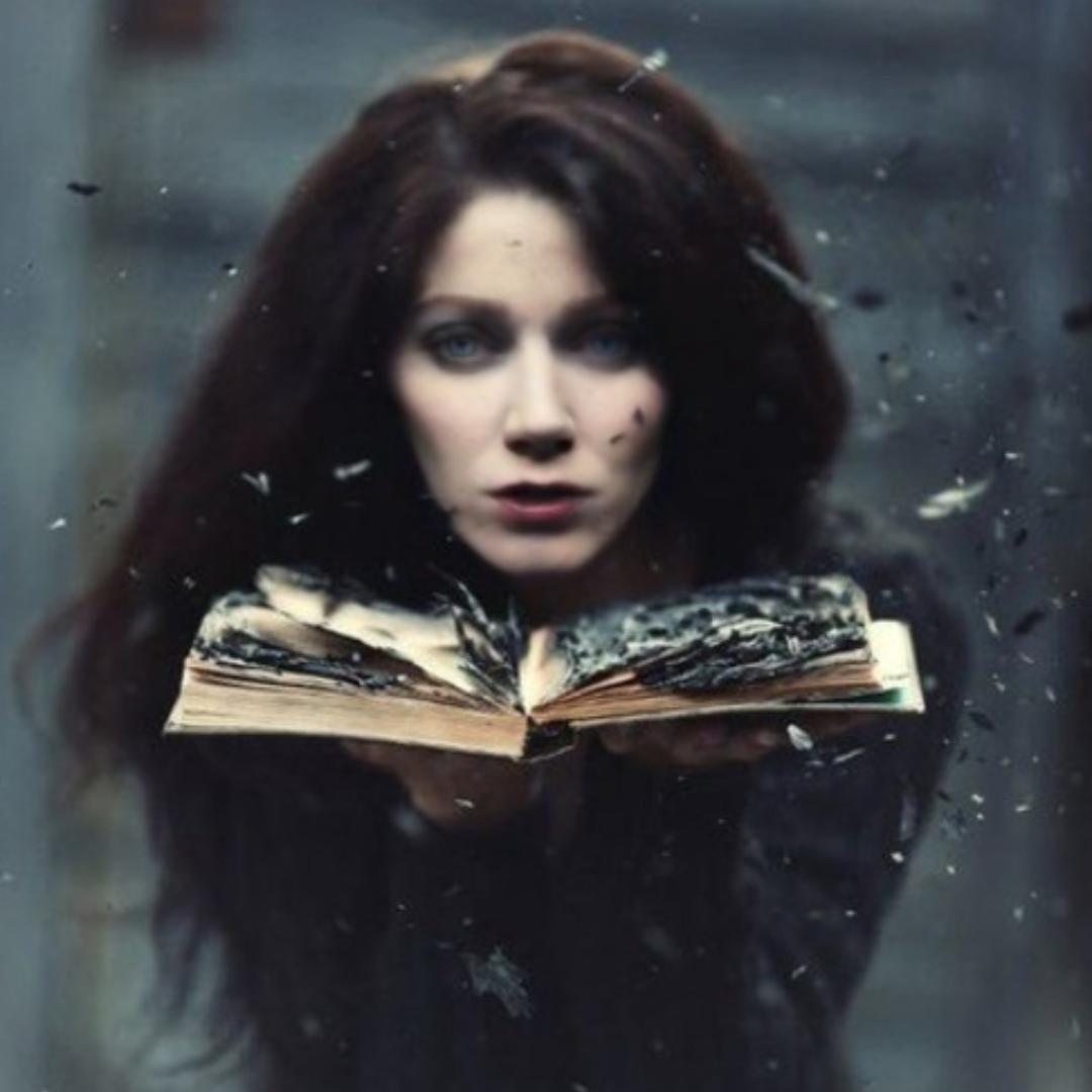 Jessica holds an old book open in front of her. The pages are burnt and falling apart.
